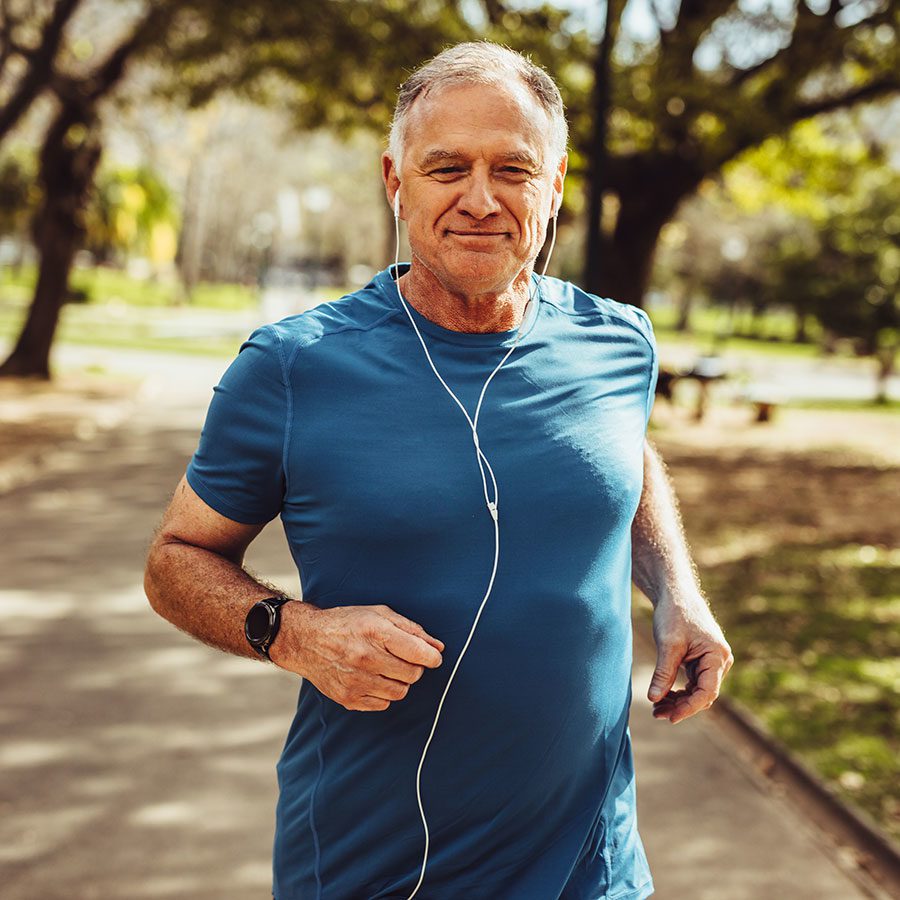 Jogget in a blue shirt, running while listening with headphones in